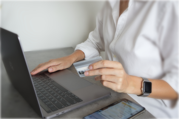 person holding credit card and typing on the laptop